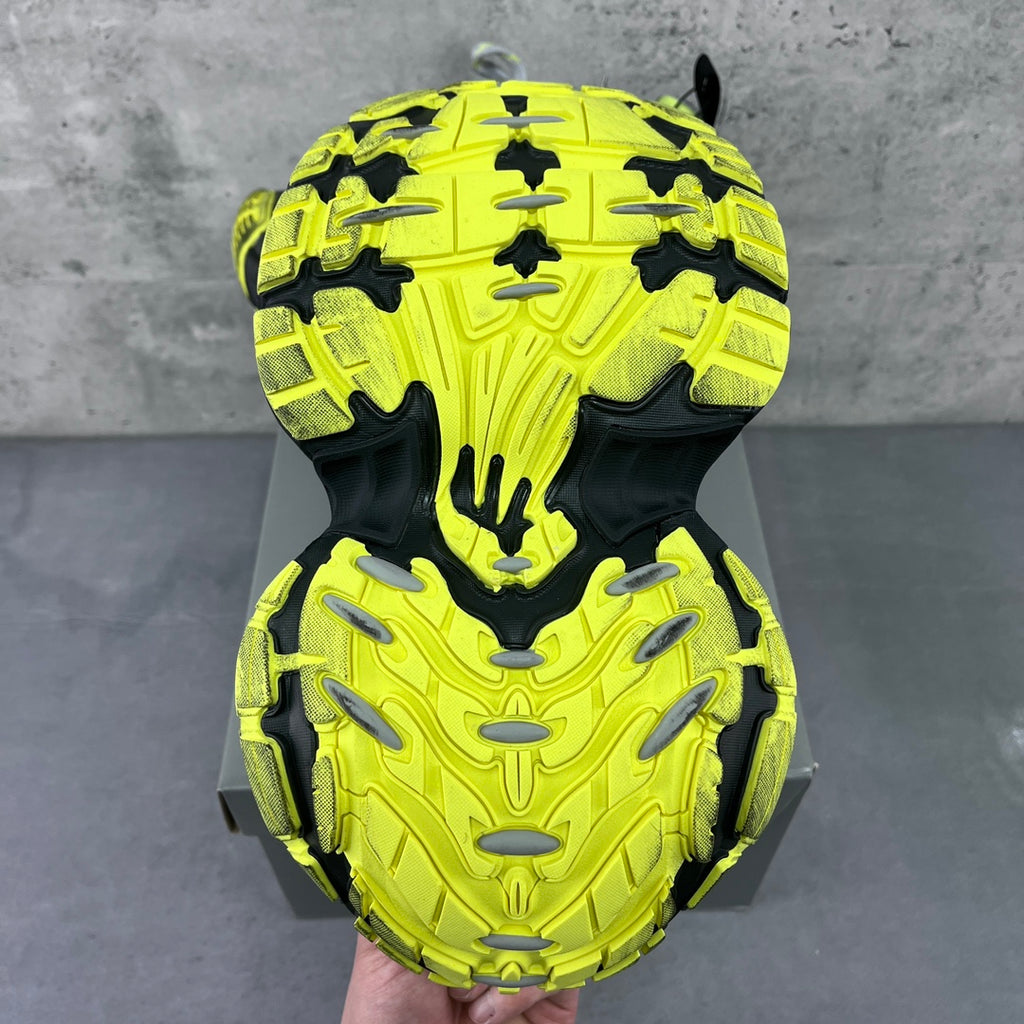 Chunky sneaker outsole with neon yellow tread pattern over black rubber