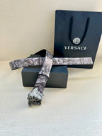Floral leather belt with silver Medusa buckle, shown with matching box