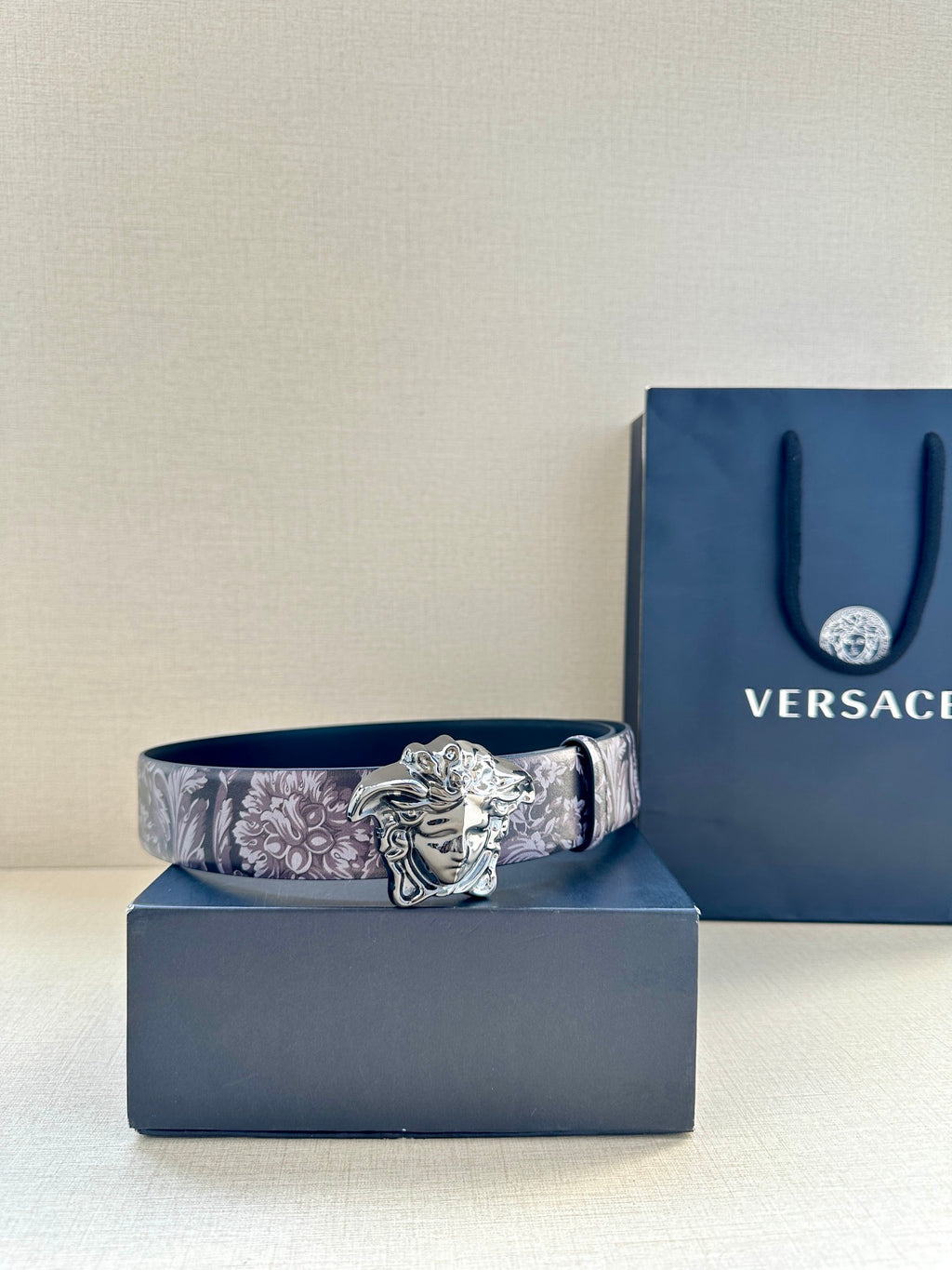 Floral leather belt with silver Medusa buckle on dark plum strap