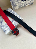Red and black leather belts with oval logo buckle and punched holes.