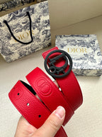 Red leather belt strap with embossed logo and oval buckle, punched holes.