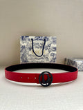 Red leather belt with circular logo buckle and punched holes.