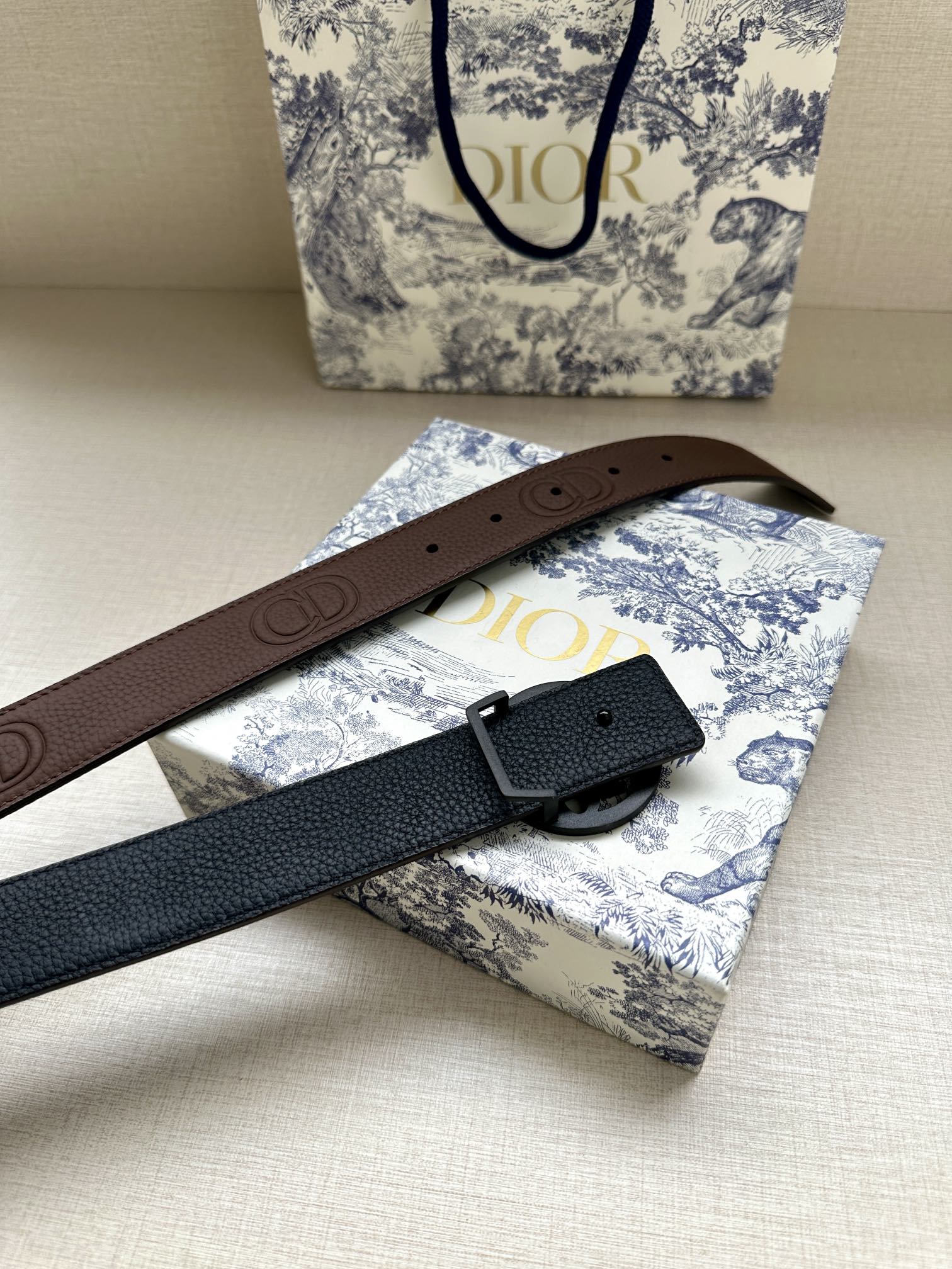 Dior belt with brown and dark blue straps, circular logo buckle and holes
