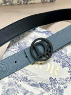 Dior belt detail: light blue textured strap with round dark CD buckle and hole end