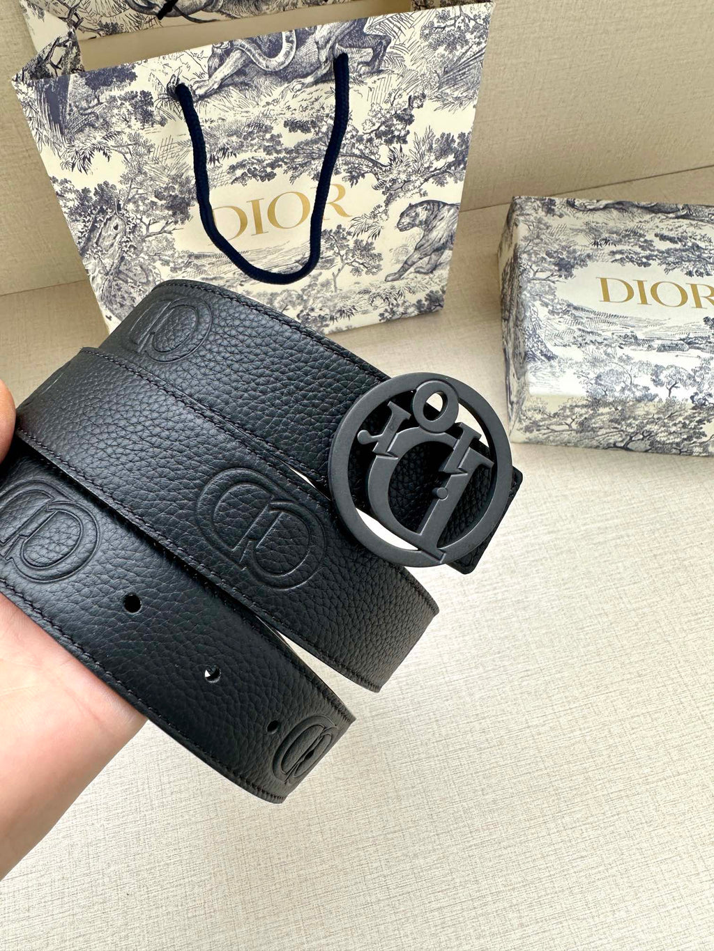 Dark leather belt strap with embossed Dior monogram and oval logo buckle