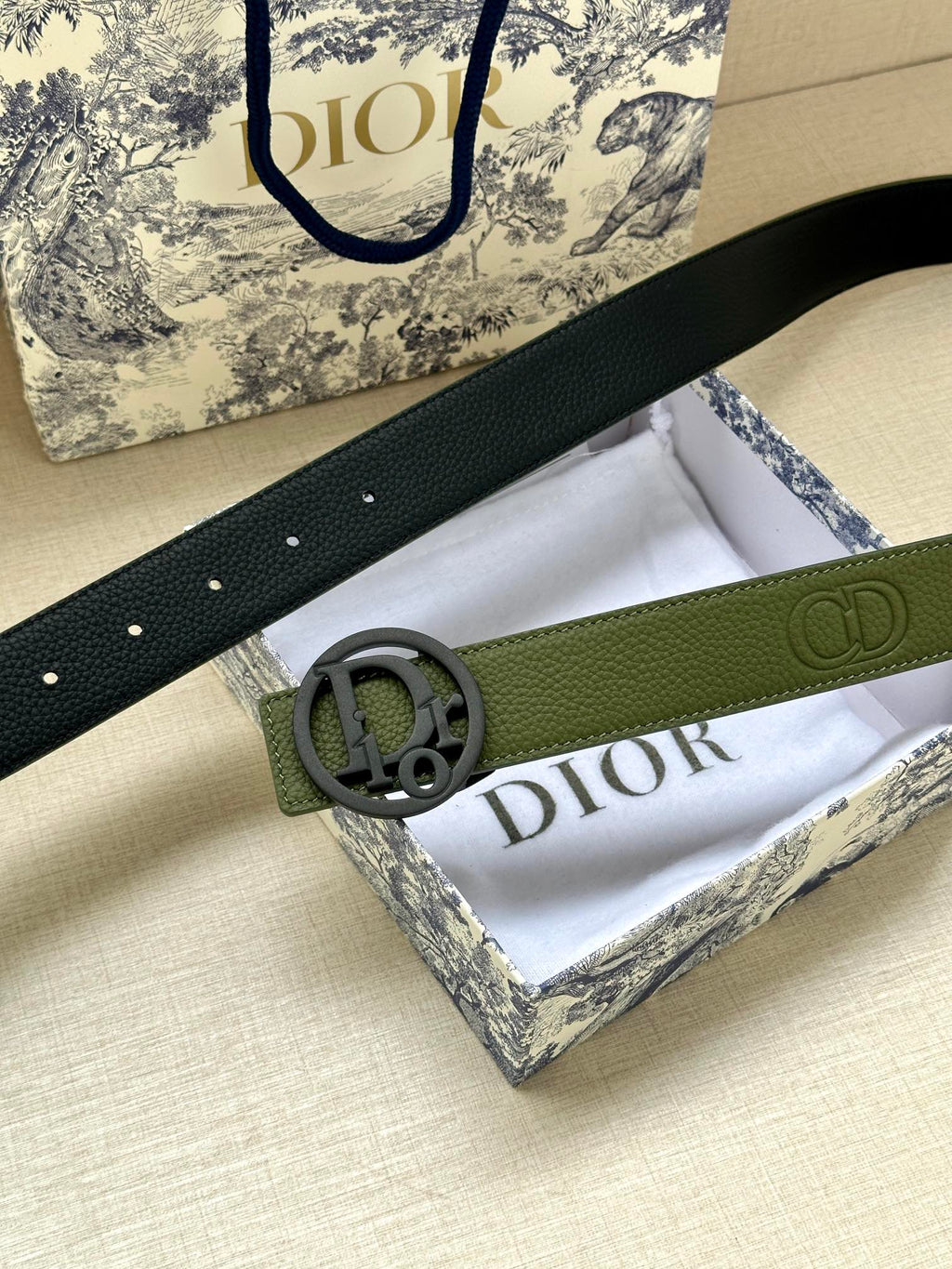 Green leather belt with textured strap and circular logo buckle
