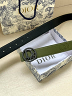 Green leather belt with textured strap and circular logo buckle