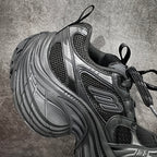 Balenciaga chunky sneakers side profile, black laces over dark mesh and silver panels