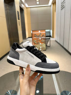 Chanel unisex sneaker in hand, black-and-white low-top with lace-up closure and logo