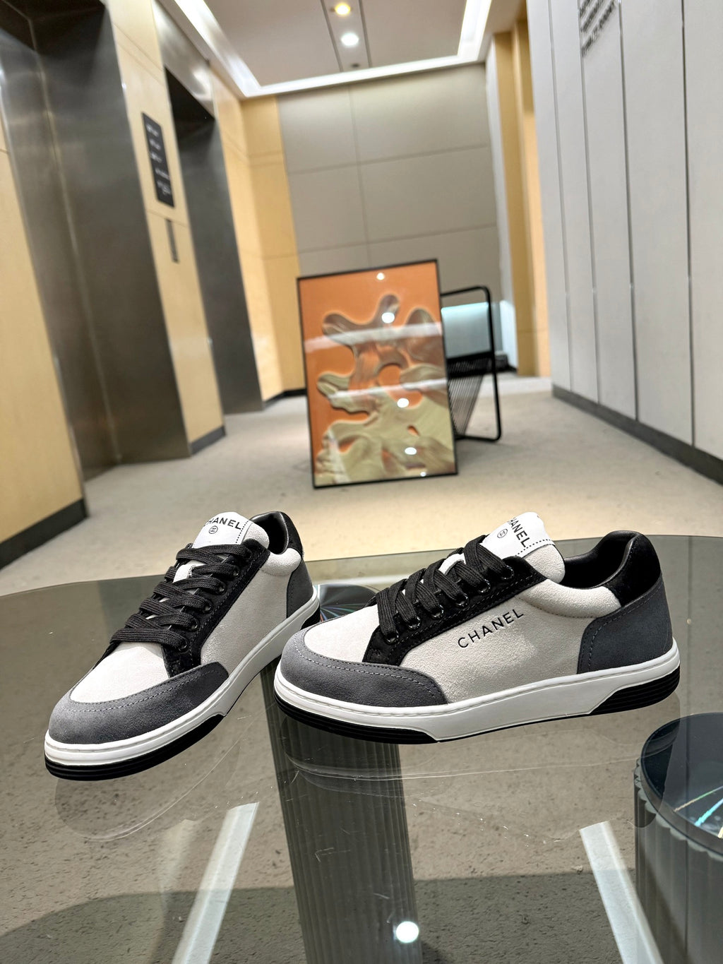 Chanel unisex sneakers display: white-and-black pair and black-and-white pair side-by-side