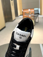 Chanel unisex sneaker close-up, white tongue patch with black laces and side stripe