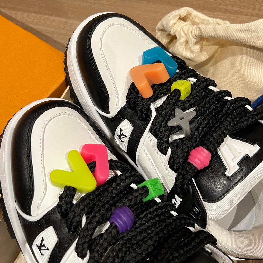 Louis Vuitton trainer sneakers close-up, black laces with multicolor charm clips