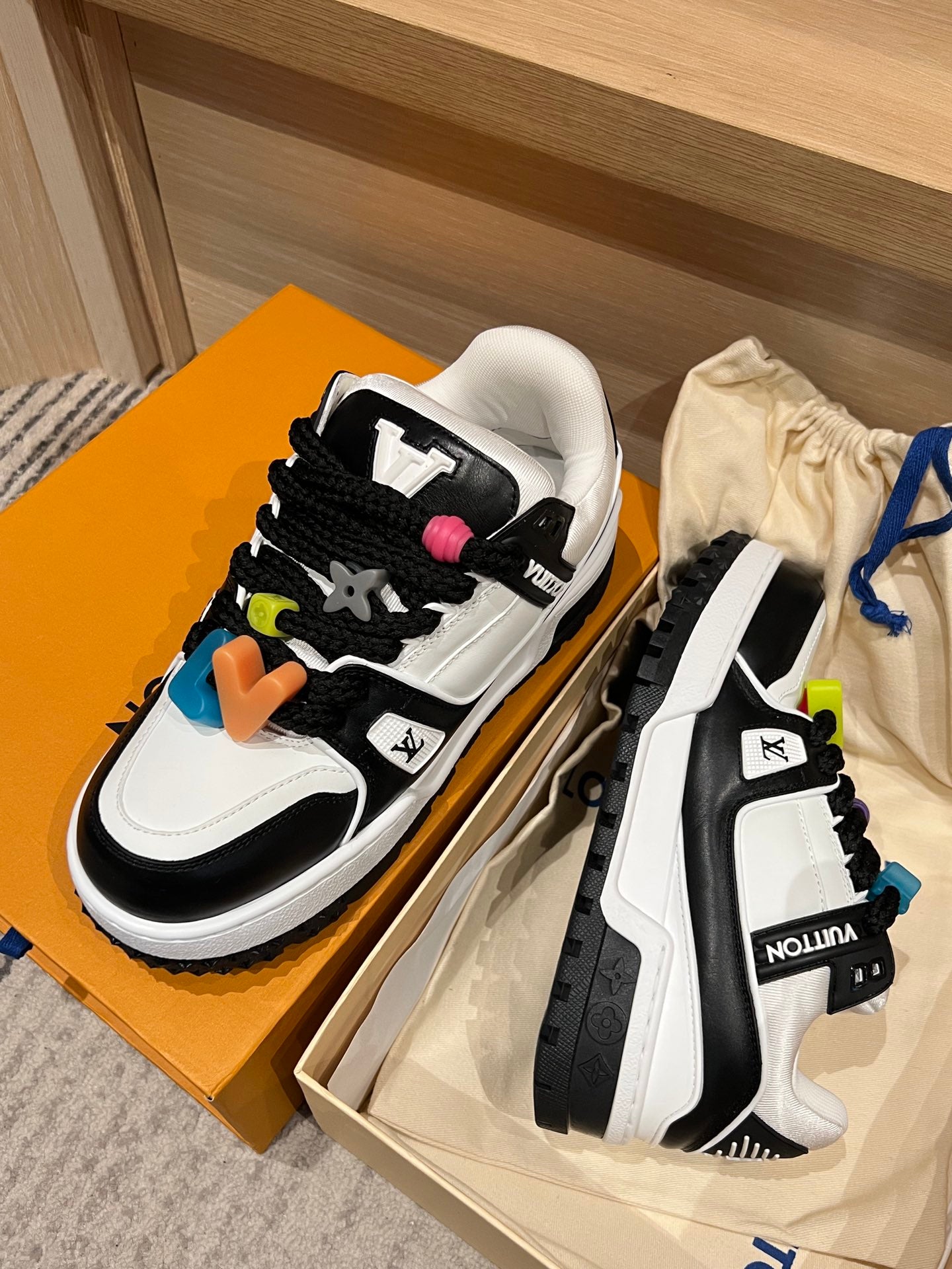 Louis Vuitton trainer sneakers pair, white leather with black trim and colorful charms