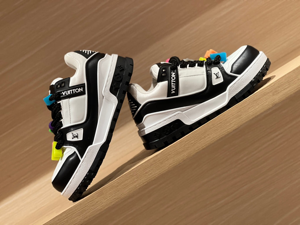 Louis Vuitton trainer sneakers side view, white and black uppers with logo patches