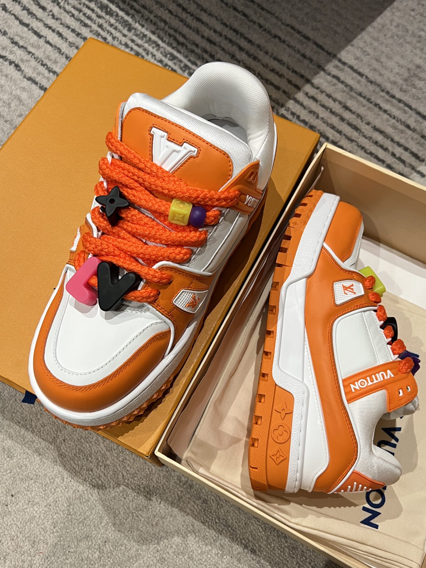 Orange/white Louis Vuitton trainer sneakers with orange laces and charm details