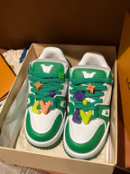 Green-and-white low-top sneakers with colorful lace charms in a shoe box
