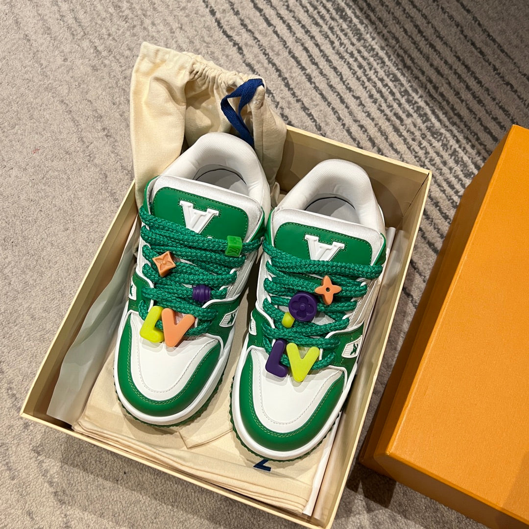 Green-and-white low-top sneakers with lace charms and star detail in a box