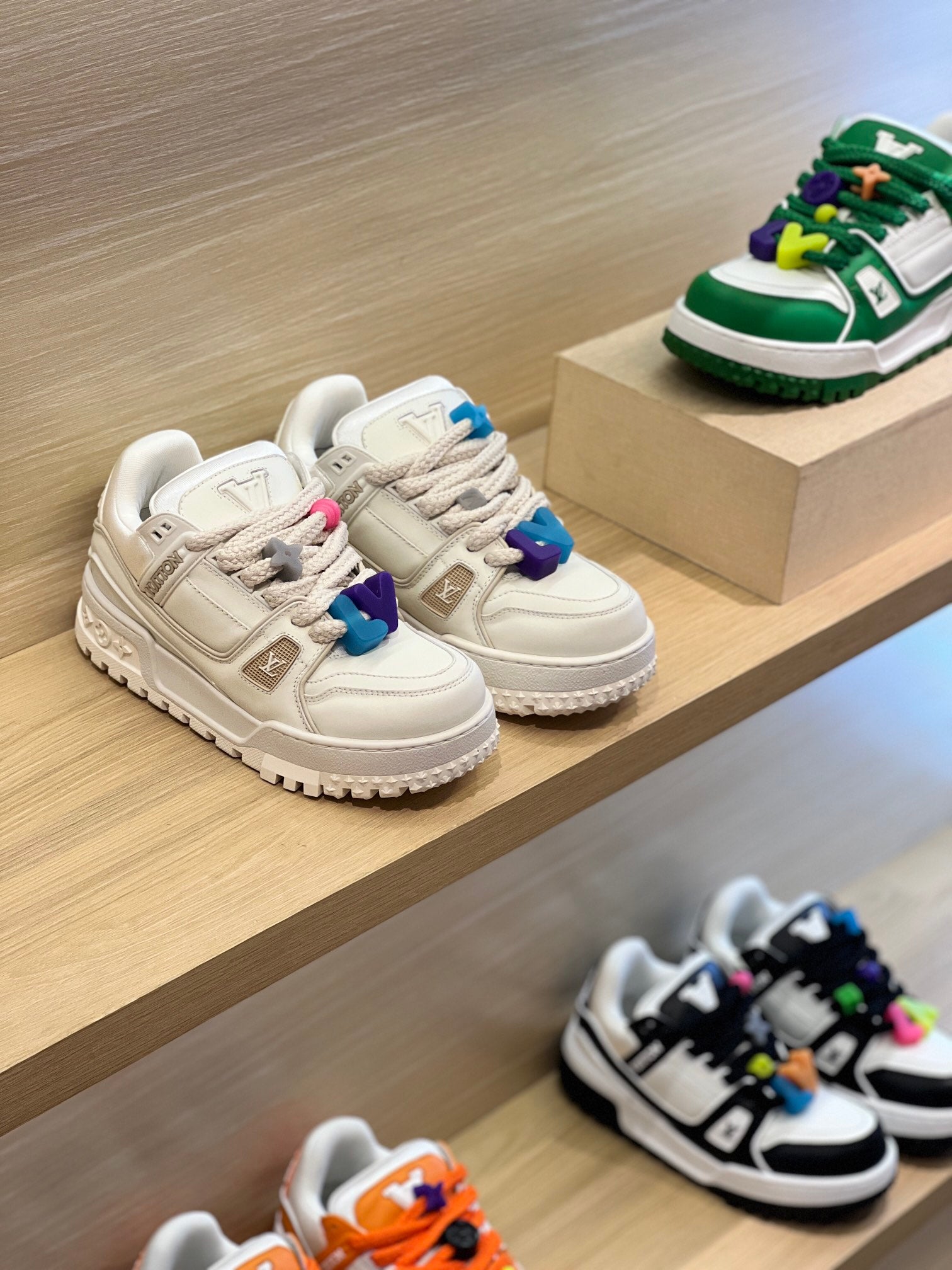Louis Vuitton trainer shoes on display, white leather with blue and purple details