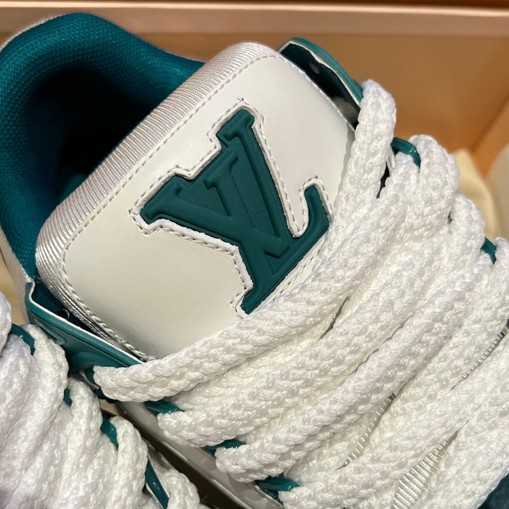 Louis Vuitton sneaker side panel close-up, large teal LV emblem on white