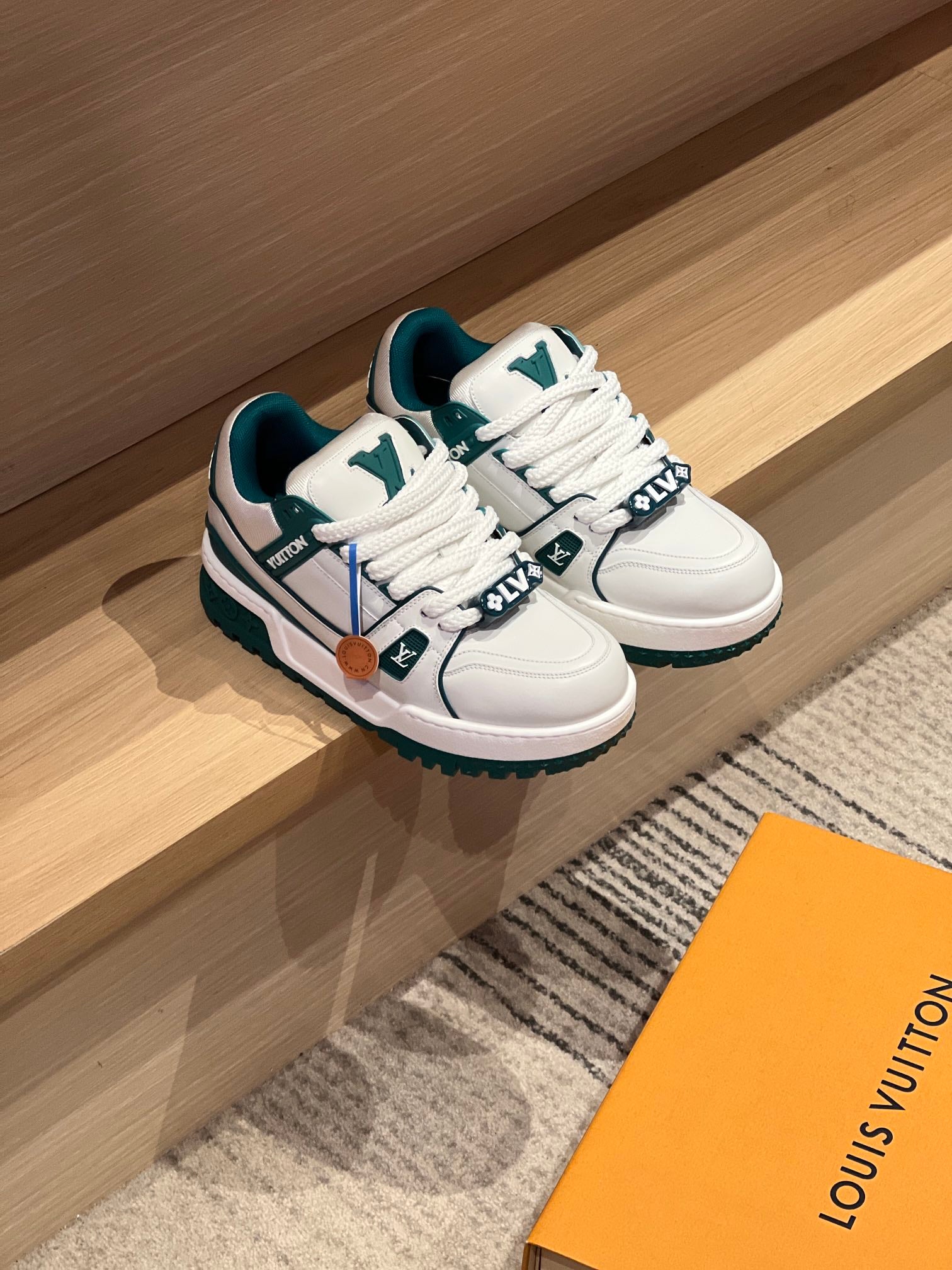 Pair of Louis Vuitton low-top sneakers, white with teal accents, white laces