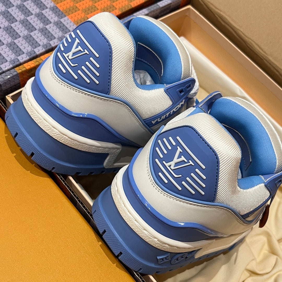 Trainer shoes with blue heel panels and thick soles inside a shoe box