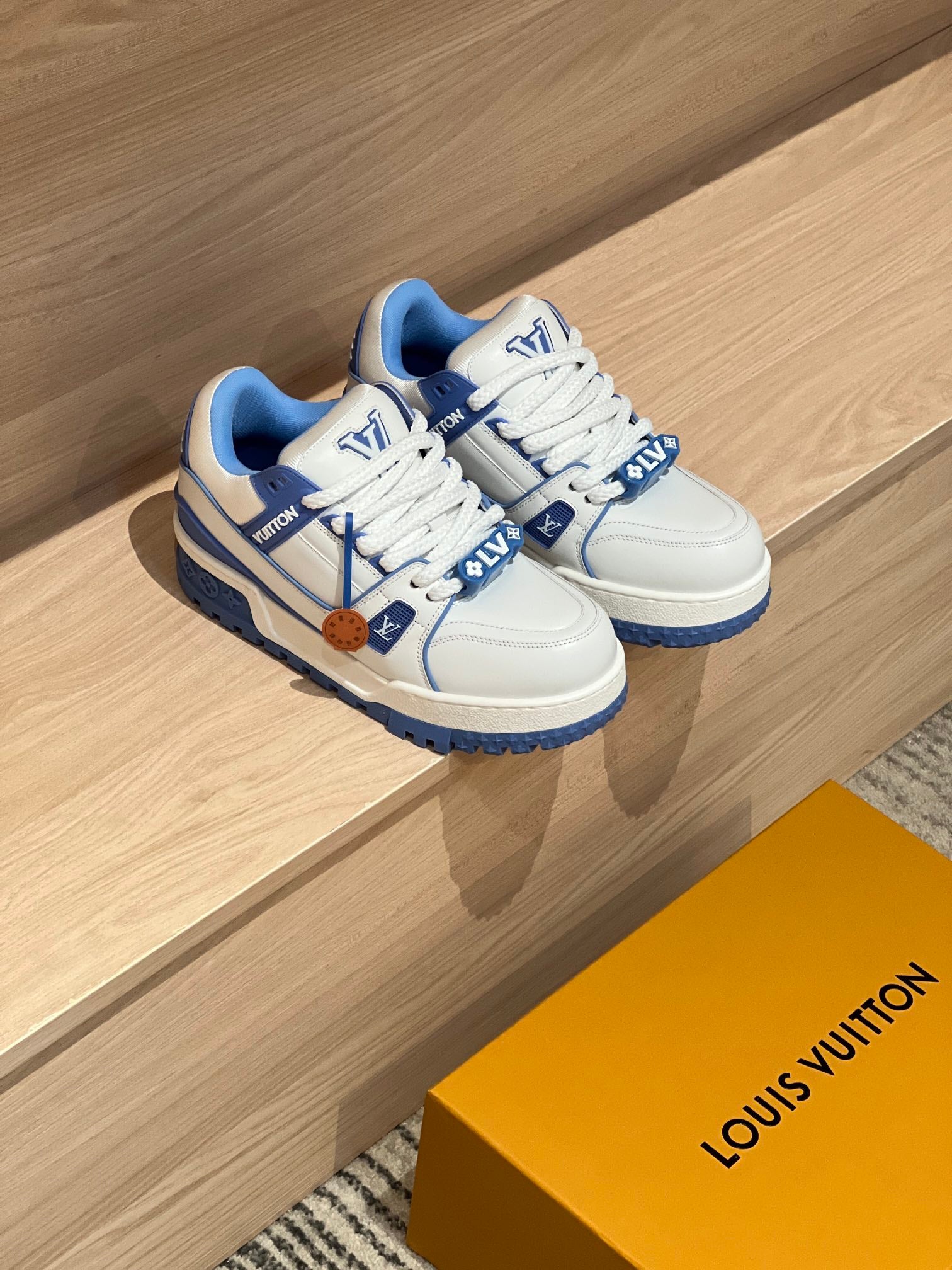 Pair of white and blue trainer shoes with lace-up front and textured sole