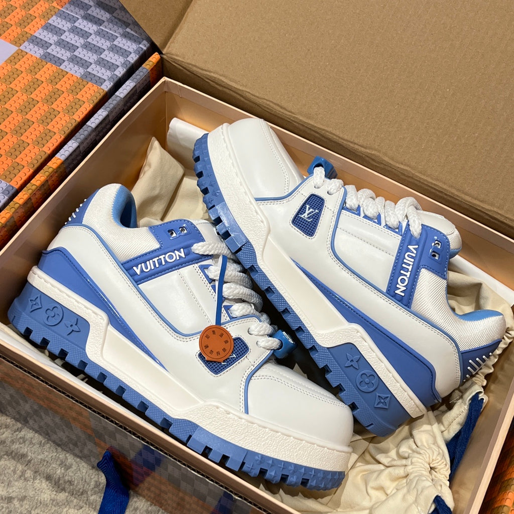 White and blue trainer shoes with blue paneling and rubber sole in a box