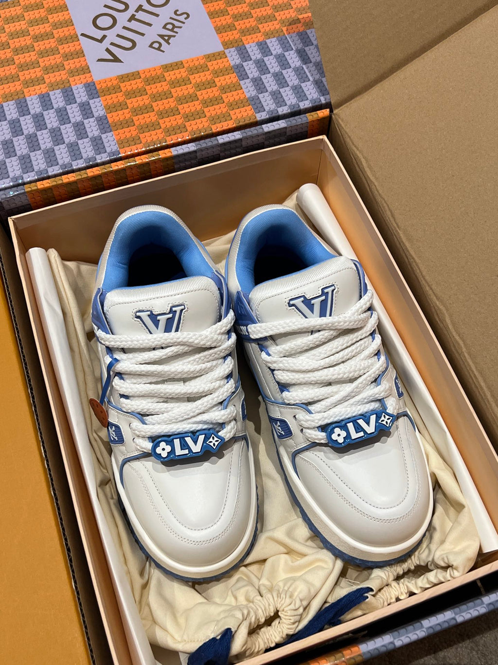 Pair of white and blue Louis Vuitton trainer shoes in a shoe box