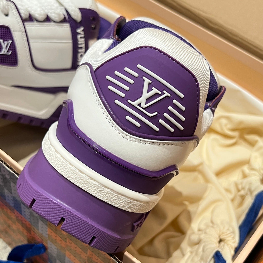 White and purple sneaker heel close-up with embossed logo patch and cushioned collar