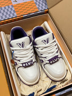 White and purple sneakers with lace-up ties and branded panels in shoe box