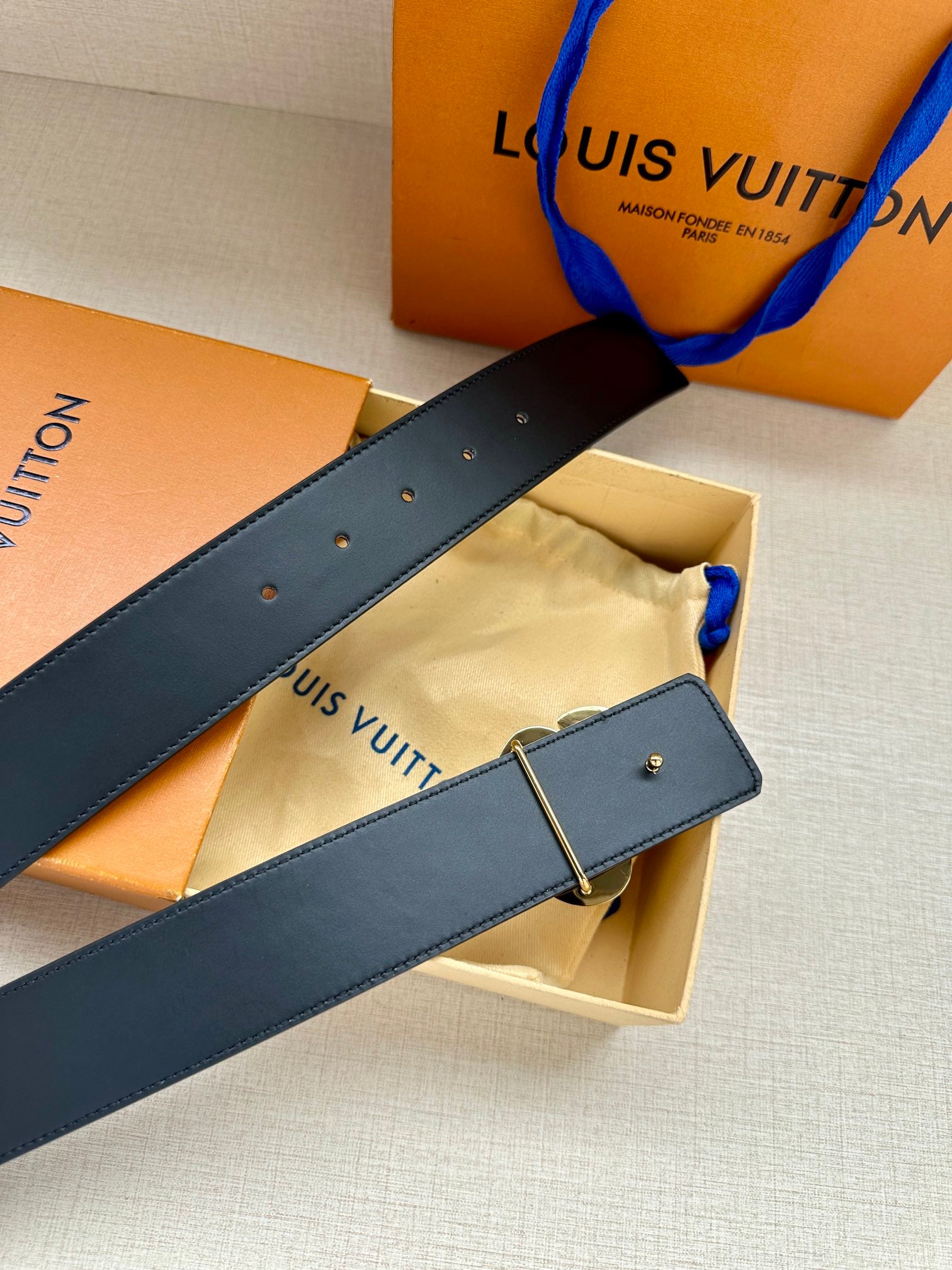 Dark blue leather belt with silver-tone buckle and rectangular keeper loop.