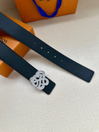 Dark blue leather belt strap with silver-tone monogram keeper, eyelets visible.