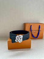 Dark blue leather belt with silver-tone monogram buckle on box.
