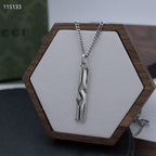 Silver-tone chain necklace with long rectangular pendant on hex display