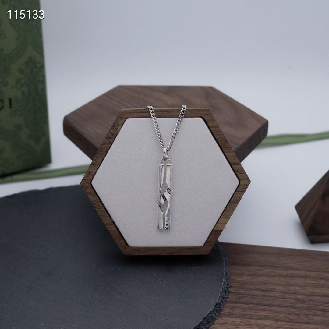 Silver-tone chain necklace with rectangular pendant on hex display stand