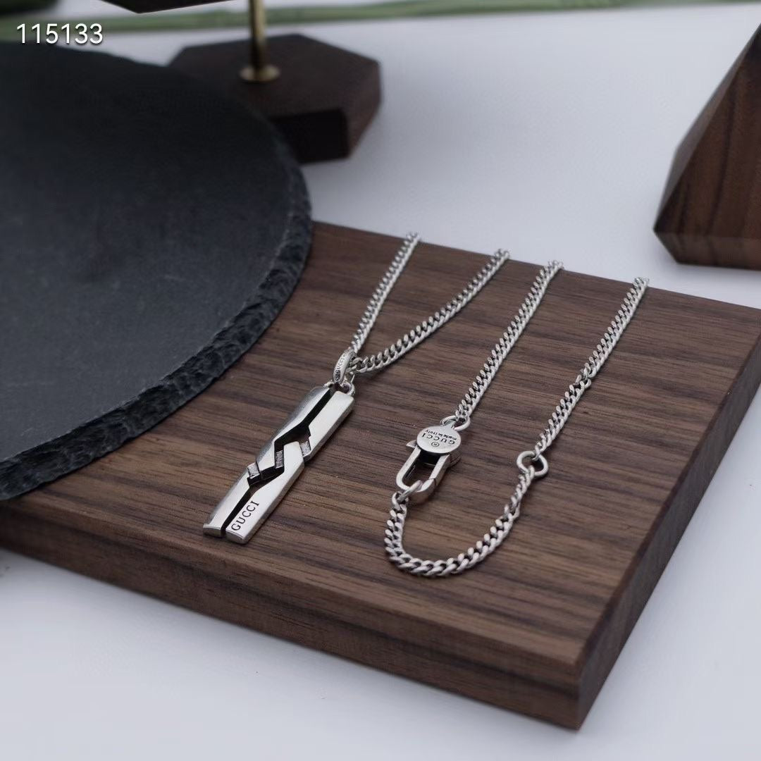 Silver-tone pendant and charm necklaces on wooden tray