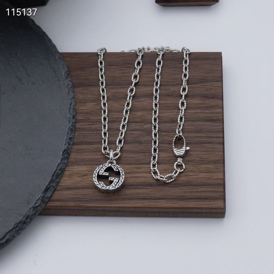 Gucci silver-tone pendant necklace and matching chains on a tray