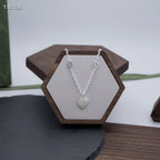 Gucci silver heart pendant necklace on a hexagon jewelry display stand