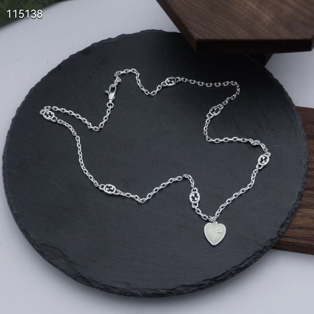 Gucci silver heart pendant necklace with chain links on a black cushion display