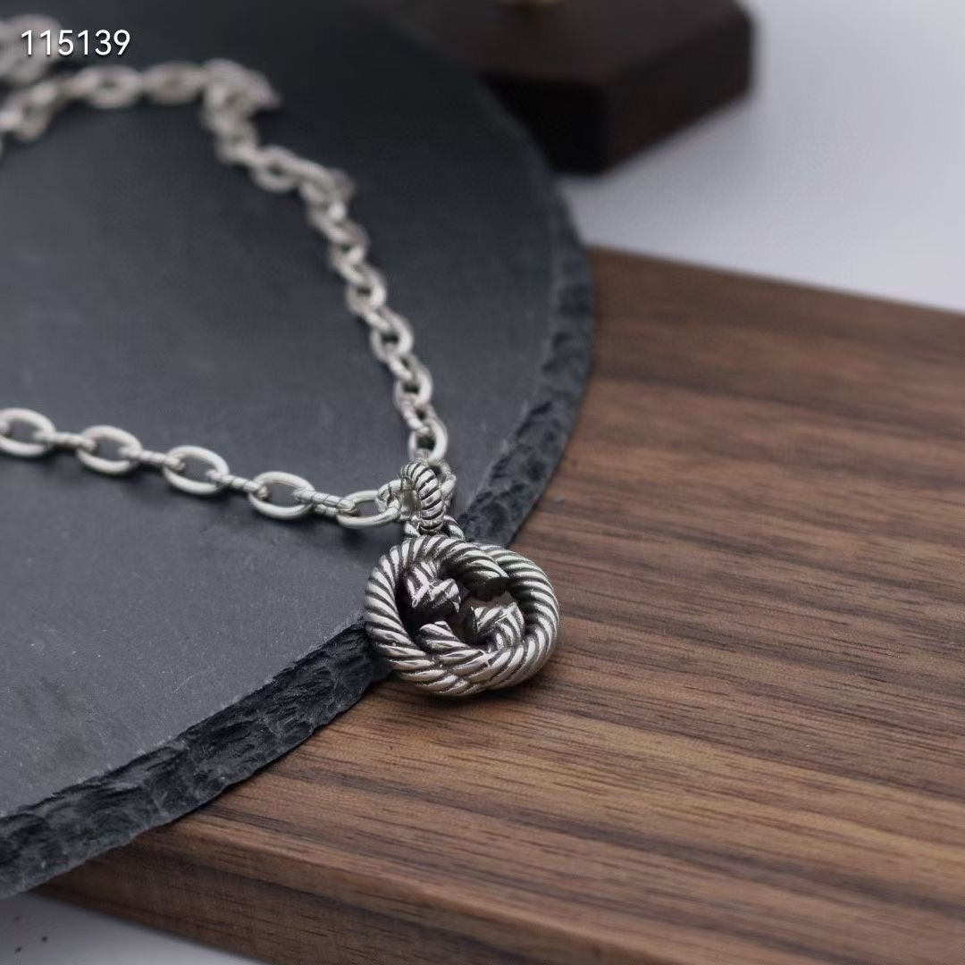 Silver-tone round knot pendant necklace with linked chain and detailed center knot