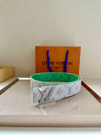 White monogram belt with green underside and gold buckle