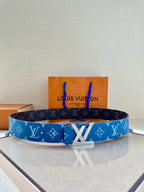 Blue monogram Louis Vuitton belt with gold-toned buckle on a display stand