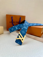 Blue monogram belt with gold-toned LV buckle resting on display boxes