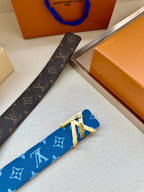 Brown monogram belt strap with gold-toned buckle detail next to blue belt