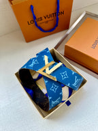 Blue monogram belt with gold-toned LV buckle, displayed in a box