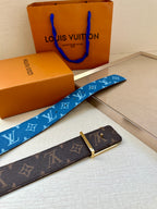 Blue monogram belt and brown monogram belt with gold-toned buckles in boxes