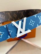 Blue monogram belt close-up with white LV tab and gold-toned buckle