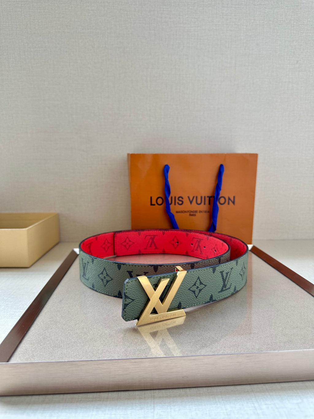 Green-gray monogram belt with red underside and gold-tone LV buckle