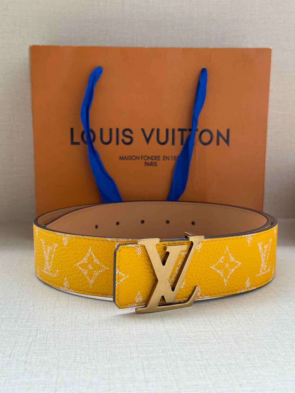 Yellow monogram leather belt with silver LV buckle and tan underside