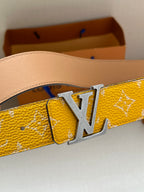 Yellow patterned leather belt with silver LV buckle close-up